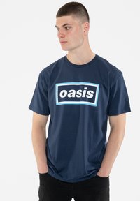 Navy blue cotton t-shirt with a crew neck, featuring a rectangular white logo "oasis" outlined in light blue across the chest.
