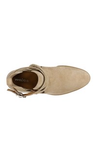 Stivaletto in suede beige con punta arrotondata, dettaglio fibbia e texture morbida; suola piatta; design minimalista e senza motivi visibili.
