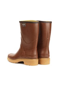 Bottes de pluie en caoutchouc marron avec une finition texturée, garniture marron en haut, et une semelle marron clair présentant un motif pour une meilleure adhérence. Logo affiché.