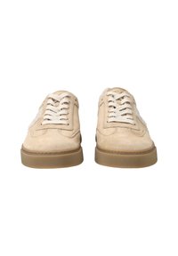Baskets en suède beige avec un panneau latéral texturé, des lacets blancs et une semelle en caoutchouc beige, présentant un bout arrondi et un design minimaliste.