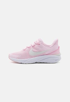 Helle rosa Sportschuh mit strukturiertem Mesh-Obermaterial, weißem Swoosh-Logo, gepolsterter Kragen und kontrastierender weißer Sohle mit einem Grip-Muster.