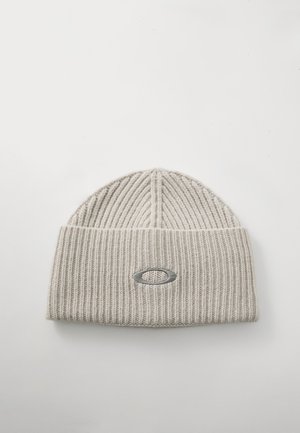 Jasnoszara, prążkowana czapka beanie z podwiniętym mankietem i małym tłoczonym logo z przodu. Miękka tekstura z pionowymi liniami.