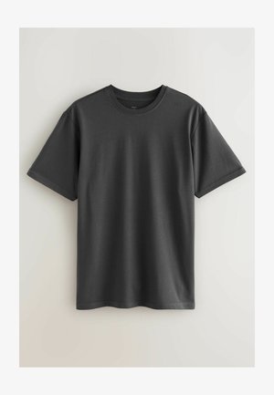 Siva bombažna majica z okroglim ovratnikom, kratkimi rokavi in sproščenim krojem. Ima gladko teksturo in urejen, enakomeren šiv.