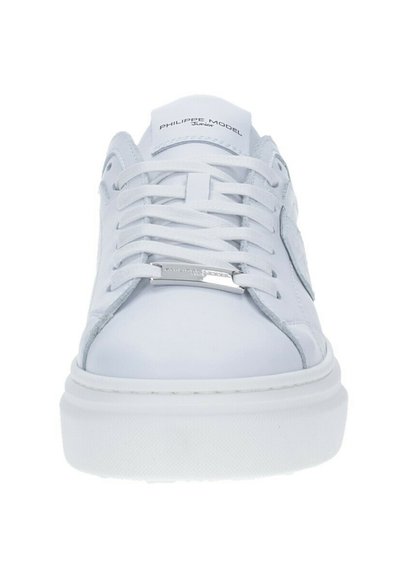 Sneakers bianchi in pelle con una texture liscia, punta rotonda, lacci piatti e una suola spessa bianca con un discreto marchio sulla linguetta.
