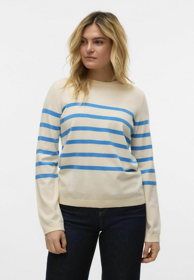 Crème sweater met blauwe horizontale strepen, ronde halslijn en lange mouwen. Zachte textuur en slim-fit ontwerp, gedragen met donkere jeans.