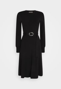 Robe noire à manches longues, longueur aux genoux, avec un col rond et une ceinture attachée ornée d'une boucle ovale argentée à la taille.