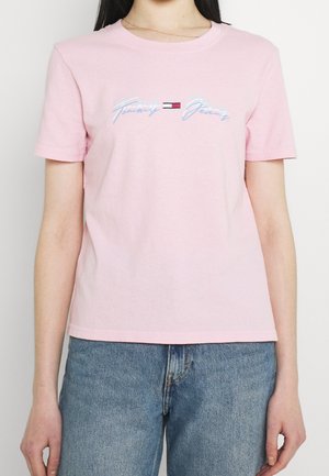 Różowy bawełniany T-shirt z krótkim rękawem, z jasnoniebieskim logo "Tommy Jeans" na piersi na gładkim materiale. Luźny krój.