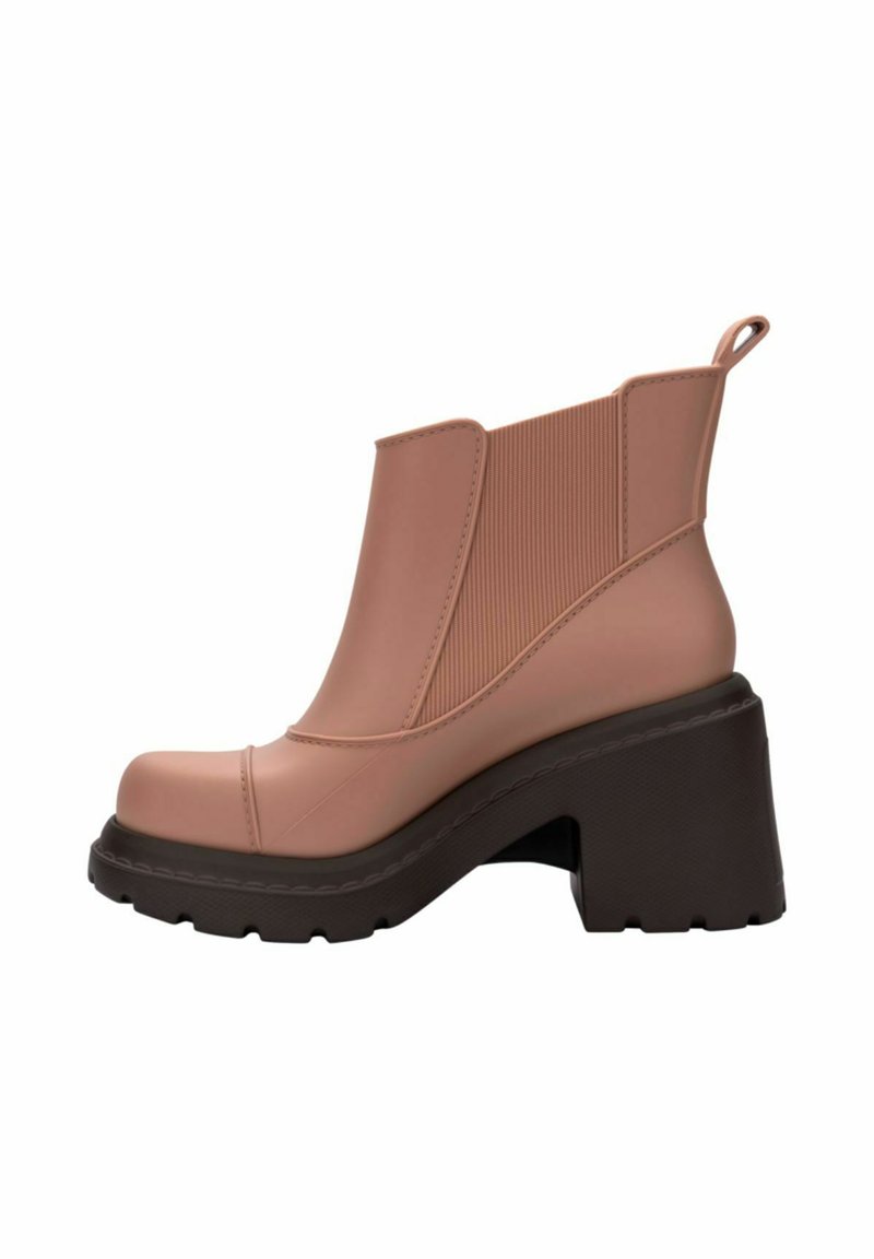 Różowy gumowy botek za kostkę z masywnym czarnym obcasem i elastycznymi panelami bocznymi. Gładka faktura, okrągły nos oraz tylna pętelka ułatwiająca zakładanie.