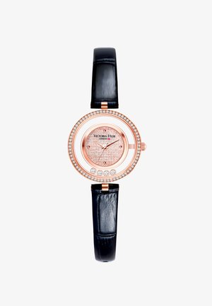 Roségoldfarbene Uhr mit rundem, mit Kristallen besetztem Gehäuse, schwarzem Lederarmband und strukturiertem pinken Ziffernblatt, das den Markennamen zeigt.