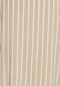 Tessuto beige con strisce verticali bianche, trama liscia, design leggero, adatto per abbigliamento casual o come strato aggiuntivo.