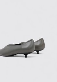 Gray leather shoes with a sleek design, tapered shape, and small pointed heel. Smooth texture, minimalistic style with no visible accents.