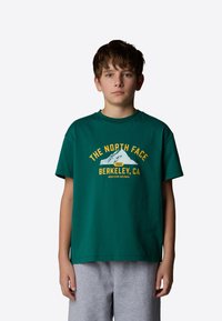 Green cotton t-shirt with short sleeves and a crew neck. Features yellow text and mountain graphic, stating "THE NORTH FACE BERKELEY, CA."