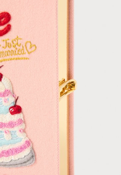 Portefeuille en tissu rose avec un design de gâteau multi-couches brodé, orné de cerises, de quincaillerie dorée et d'une texture lisse.