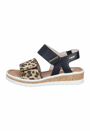 Women's sandal with leopard print front strap, black ankle strap, cork wedge sole, and white rubber outsole.