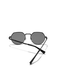 Crne osmokutne sunčane naočale s tamnosivim lećama, tankim metalnim okvirom i laganim dizajnom. Imaju podesive nosače za ugodnost.