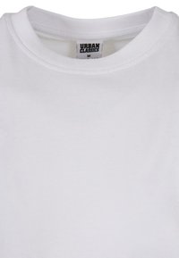 T-shirt alb din bumbac, cu guler rotund, având o etichetă care citește "URBAN CLASSICS" și mărimea "M". Textură moale și netedă.