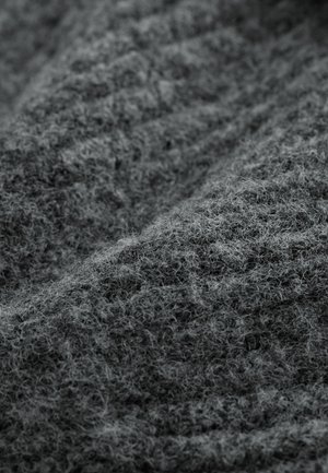 Rakenteinen harmaa kangas, jossa on pehmeä ja pörröinen ulkonäkö. Materiaalissa on epätasainen kudonta ja kerroksellinen ilme, joka korostaa syvyyttä ja pehmeyttä.