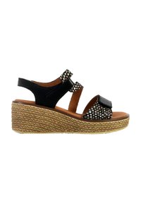 Sandales à talons compensés noires avec des accents de bride cloutés, talon en jute tissé et semelle en cuir. Comprend des brides réglables pour un maintien sécurisé.