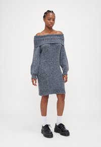 Hallide õlgadega hall kudum Kleid, millel on pikad varrukad, ribatud kaelus ja äär. Valmistatud pehmest tekstuuriga kangast, põlvepikkune ja kerge lõikega.