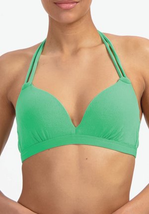 Femme portant un haut de bikini texturé vert à licou avec double bretelles et un décolleté en V profond, coupé au niveau du ventre, sur fond blanc.