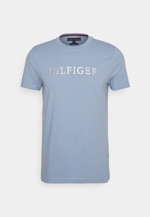 Světle modré bavlněné tričko, krátké rukávy, kulatý výstřih, s vyšitou aplikací "HILFIGER" v kontrastní barvě přes hruď.
