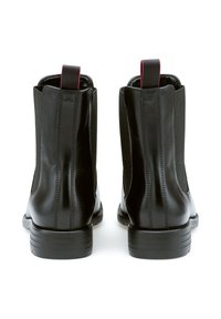 Bottines Chelsea en cuir noir avec des panneaux latéraux élastiques, une hauteur de cheville courte et une semelle nervurée. Dotées d'une languette arrière avec un accent rouge.