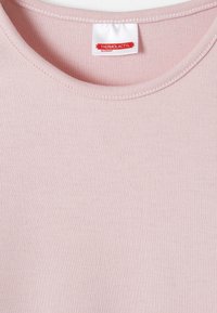 T-shirt thermique rose clair avec une texture côtelée. Encolure large et étiquette de marque portant "THERMOLACTYL par DAMART" en rouge.