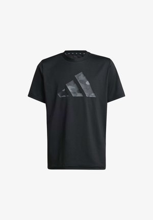 Dos jóvenes sonriendo, vestidos con camisetas negras con logos de Adidas de estampado camuflaje y pantalones camuflados negros y grises a juego, de pie uno al lado del otro.
