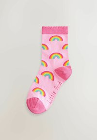 Calcetín de algodón rosa con patrones de arcoíris coloridos por todo el cuerpo y un puño rosa sólido. El nombre de la marca "Little Bird" está impreso en el costado.