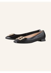 Ballerine nere in pelle con punta affilata, caratterizzate da un'elegante embellishment geometrico dorato sul davanti e un tacco basso.
