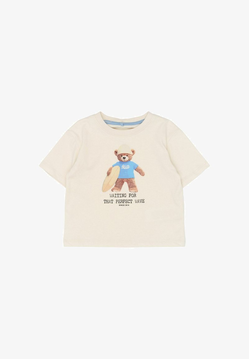 Light beige short-sleeve t-shirt, featuring a bear graphic in a blue shirt holding a surfboard, with text: "Waiting for that perfect wave".