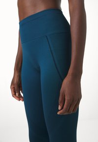 Hoge taille, teal leggings van een textuurrijke, rekbare stof met netachtige panelen en een gladde tailleband voor comfort.
