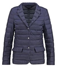 Mörkblå kviltad kavaj med slagkragar, tre silverknappar, två framfickor med lock och ett mönstrat innerfoder.