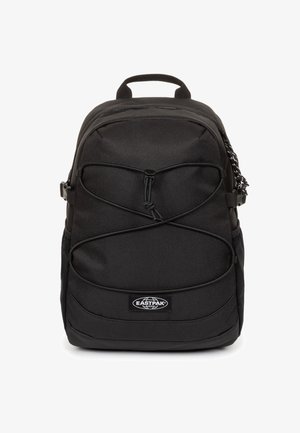 Sort Eastpak rygsæk med front elastisk snor, topgreb, sidelommer og logoemblem centreret nederst foran.