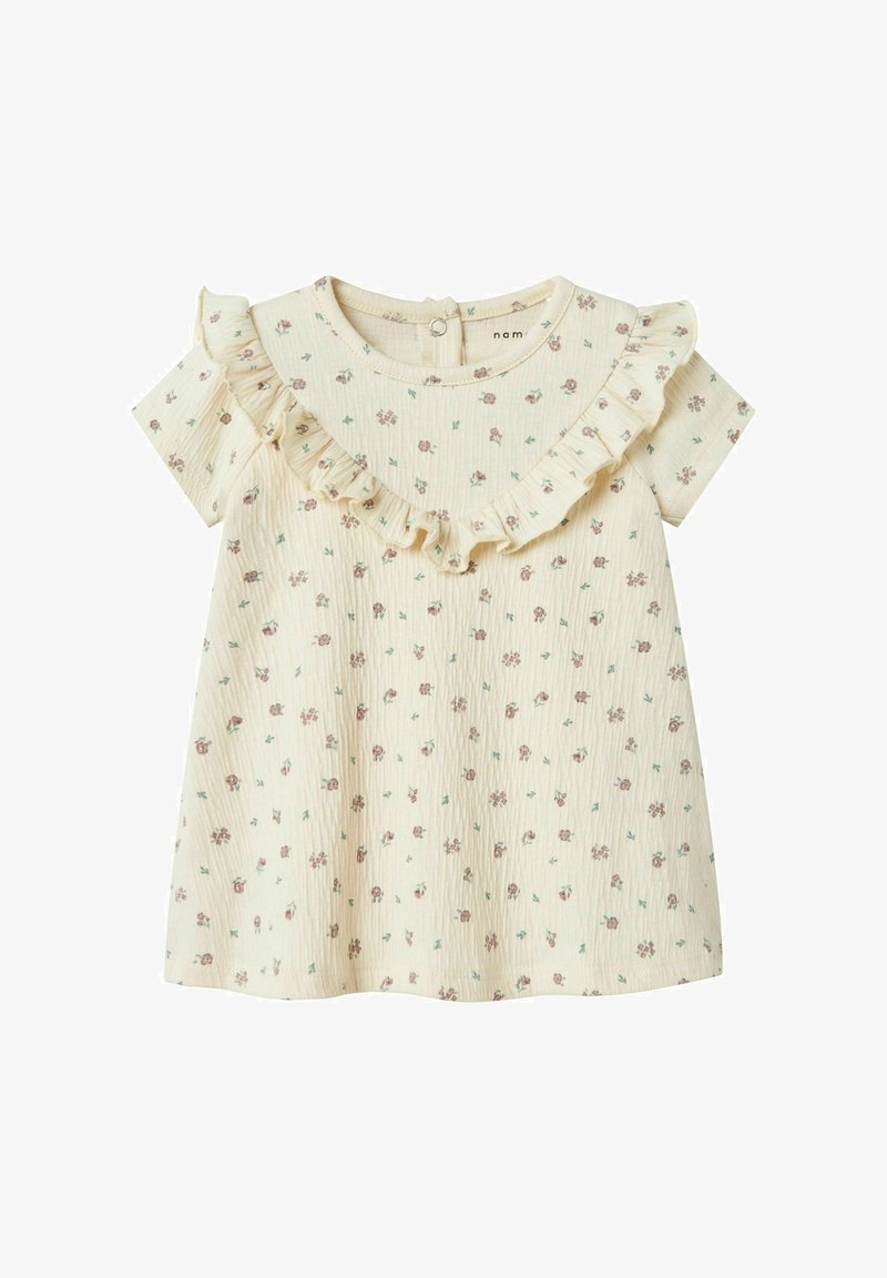 Gėlių suknelė kreminės spalvos su šviesiai purpurinėmis gėlėmis, trumpomis rankovėmis ir raukšlėtu iškirpimu; tekstūruotas audinys su subtiliomis vertikaliomis juostelėmis.