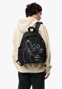 Mochila negra hecha de material de lona con diseños de contorno blanco. Incluye un bolsillo frontal y detalles del logo. Correas ajustables.