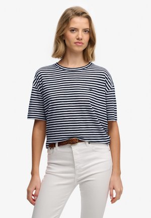 Marineblå og hvidstribet bomulds-t-shirt med rund halsudskæring og korte ærmer, der har et lille logo på brystet. Bæres med hvide bukser.