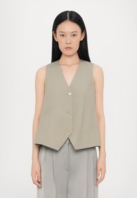 Beige ermeløs vest med dyp V-hals og fem knapper foran. Stoffet ser glatt ut med en svak glans. Enkel, rett snitt design.