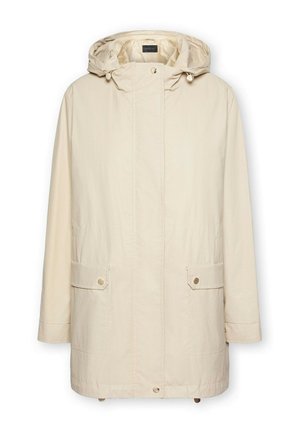 Chaqueta impermeable beige con capucha, cierres de broche en la parte delantera, dos bolsillos frontales y un ajuste ligeramente oversize. Textura suave y diseño minimalista.