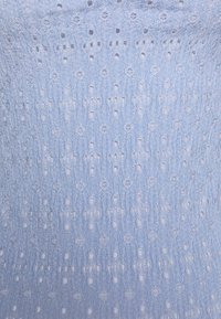 Světle modrá tkanina s texturovaným vzorem, která obsahuje malé dírky a vyvýšené květinové motivy, vytvářející jemný a vzdušný vzhled.