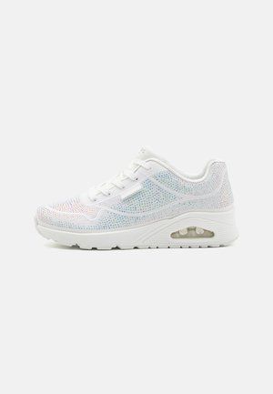 Zapatilla blanca con una parte superior de malla texturizada adornada con coloridos strass, con una mediasuela acolchada y una unidad de aire visible.