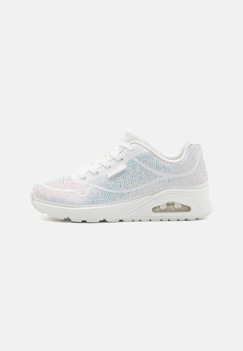 Zapatilla blanca con una parte superior de malla texturizada adornada con coloridos strass, con una mediasuela acolchada y una unidad de aire visible.