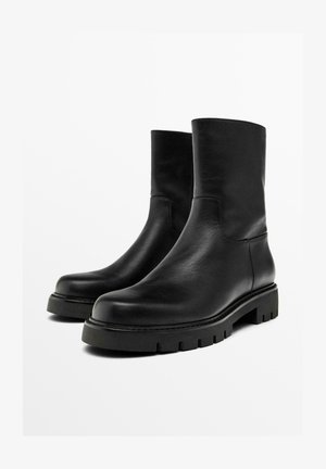 Black leather ankle boots with a smooth texture, rounded toe, and chunky treaded sole. Minimalist design, no visible hardware or accents.