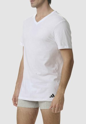Weißes Baumwoll-T-Shirt mit V-Ausschnitt und kurzen Ärmeln; verfügt über ein schwarzes Adidas-Logo in der unteren linken Ecke; glatte Textur.