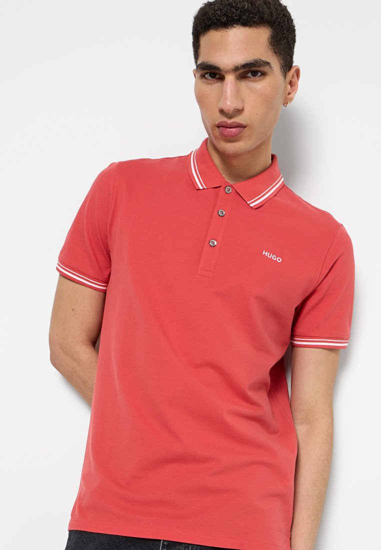 Czerwona koszulka polo wykonana z bawełny, z klasycznym kołnierzykiem, trzema guzikami i kontrastowymi białymi paskami na kołnierzyku i rękawach.