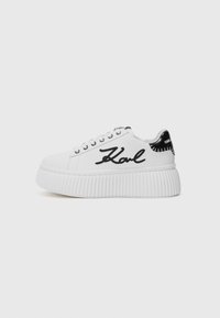 Hvit sneaker med en teksturert plattformsåle, svarte lærdetaljer ved hælen, og brodert "Karl"-logo på siden.