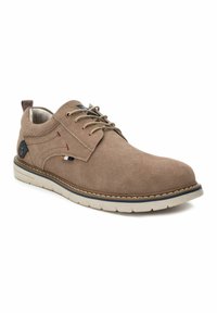 Zapato de ante marrón con cordones y superficie texturizada, que presenta acentos en azul contrastante, costuras rojas y una suela de goma blanca.