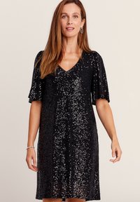 Schwarzes Paillettenkleid mit V-Ausschnitt und kurzen Puffärmeln. Es hat eine strukturierte Oberfläche und endet auf Oberschenkellänge, wobei es eine figurnahe Silhouette zeigt.