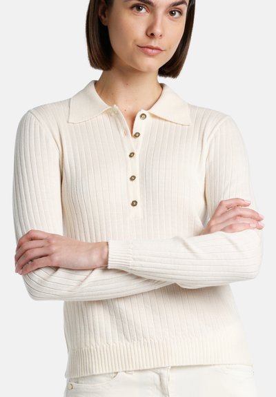 Rippendes cremefarbenes Langarm-Polohemd mit Kragen und einer Knopfleiste mit fünf Knöpfen, das ein tailliertes Design und einen flexiblen Strickstoff aufweist.