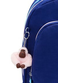 Marineblå stof rygsæk med lyseblå og pink accenter; har en pink fluffy gorilla nøglekrans fastgjort til en sølvkæde.